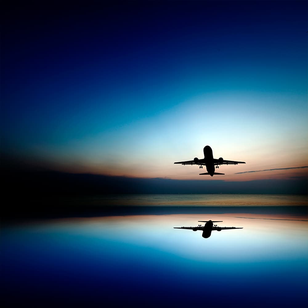 Airport Zero Emissions Planning image shows an Airplane above water in sunset with reflection