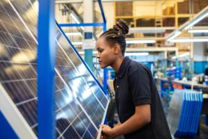 Woman inspecting a solar panel in a factory