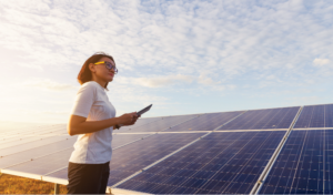 Photo of woman surveying solar panels.